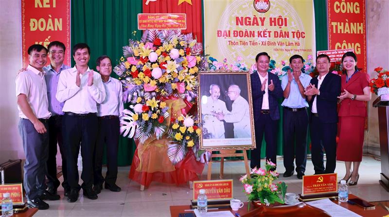 Lãnh đạo Ban Tổ chức Tỉnh uỷ và lãnh đạo xã Đinh Văn Lâm Hà tặng hoa, ảnh Bác Hồ và Bác Tôn cho Nhân dân thôn Tiên Tiến