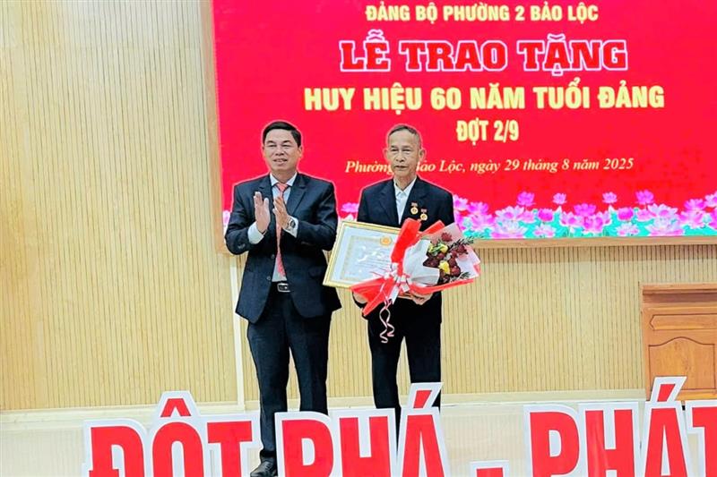 Đồng chí Nghiêm Xuân Đức, Bí thư Đảng ủy Phường 2 Bảo Lộc trao Huy hiệu 60 năm tuổi Đảng cho đảng viên