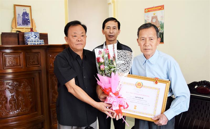 Đồng chí Lê Hồng Khánh - Phó Bí thư Thường trực Huyện ủy Đức Trọng, trao Huy hiệu 55 năm tuổi Đảng cho Anh hùng Lực lượng vũ trang Ngô Xuân Đệ